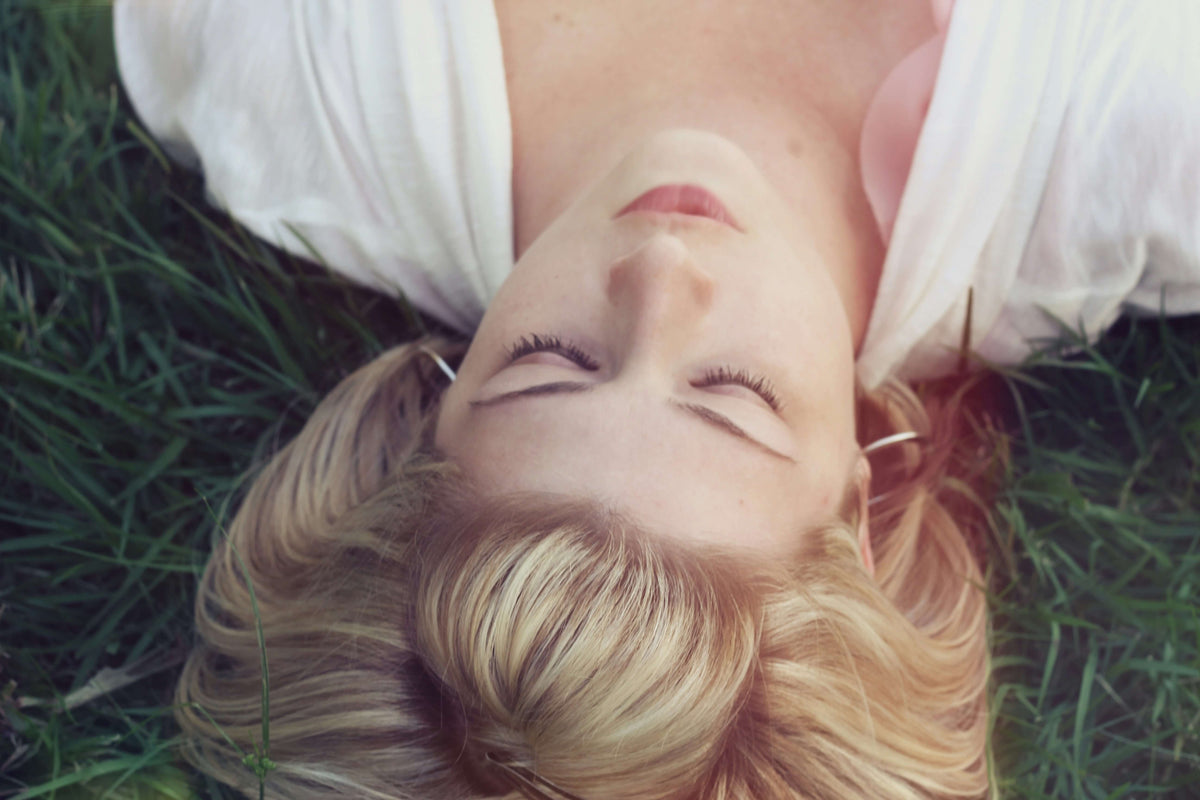 A woman with short hair lying on the grass