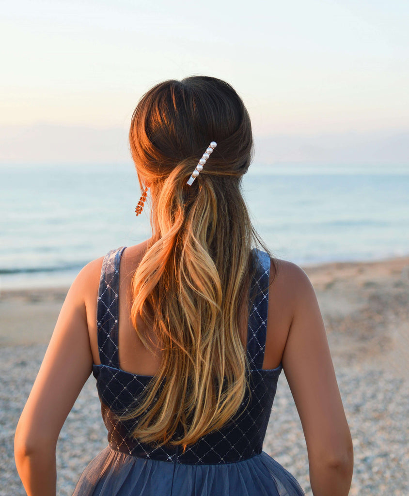 A girl on the beach with a pearl-style summer hair accessory